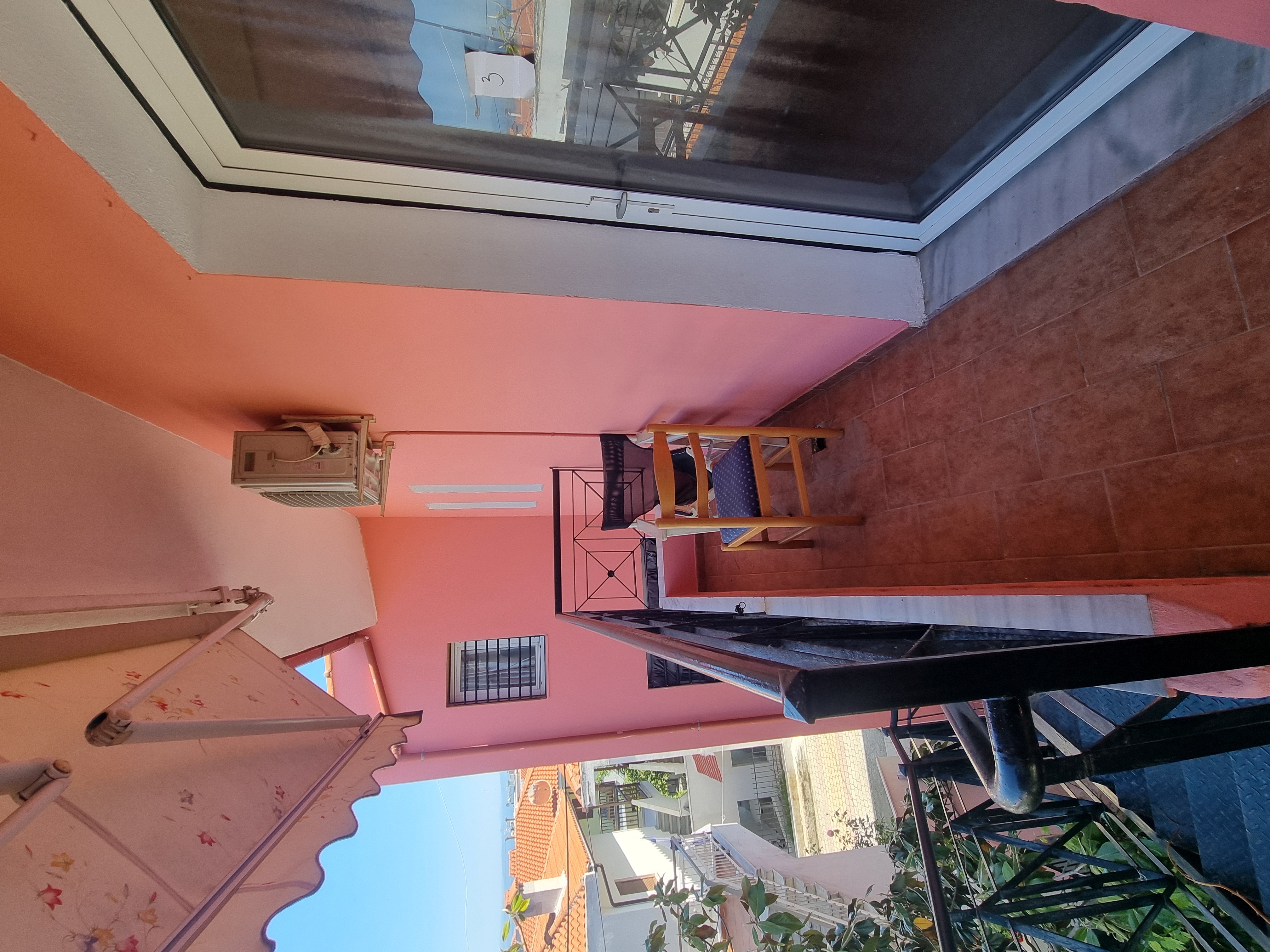 Polychrono Seabreeze Balcony Apartment balcony entrance with outdoor chair and awning