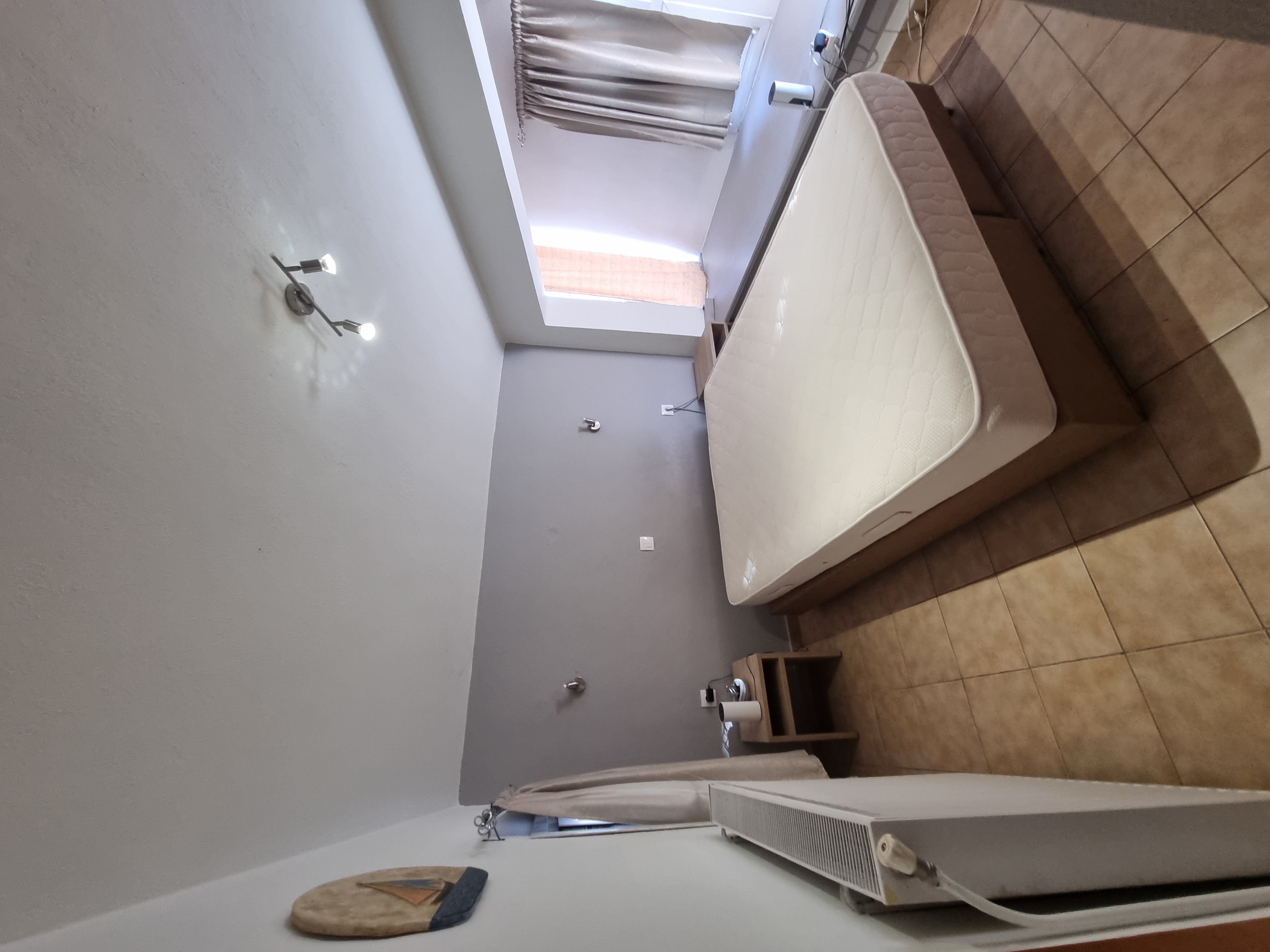 Polychrono Seabreeze Balcony Apartment double bedroom with window and bedside tables