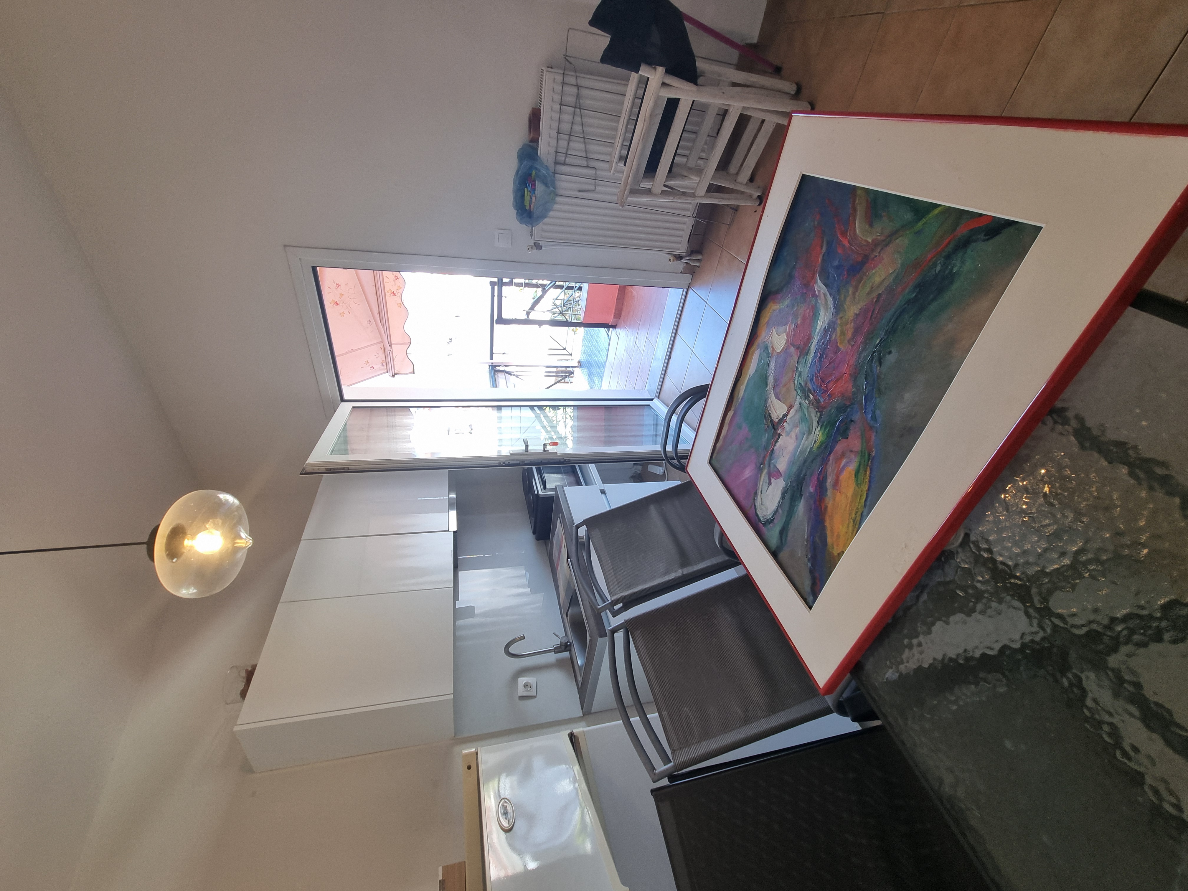 Polychrono Seabreeze Balcony Apartment kitchen and dining table beside the balcony door