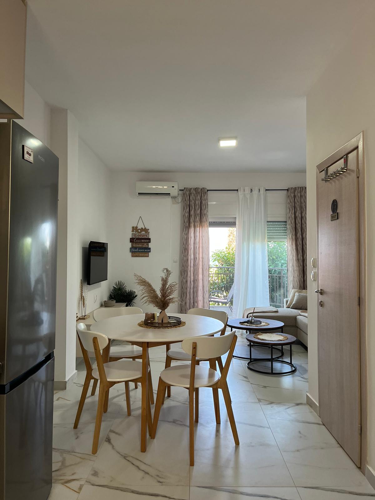 Aegean Dream dining area, living room, and balcony doors